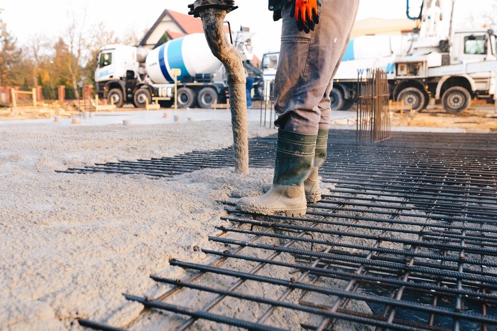 Concrete worker laying a foundation for a business in !CITY!